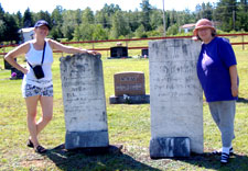 Melynda Jarratt and Sharon Olscamp by the stones of Margaret and Bridget Keenan at Our Lady of Mount Carmel Church graveyard on the Howard Road, Blackville, NB. August 2006.