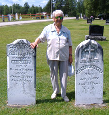 89 year old Lucy Jarratt stands next to the gravestones of her relatives, buried in Our Lady of Mount Carmel graveyard on the Howard Road, Blackville, NB. Summer 2006. 